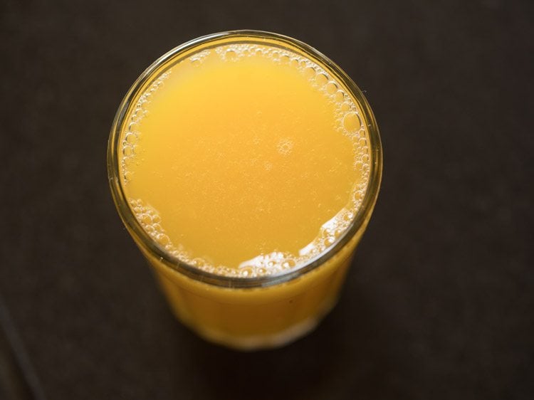 fruit punch in a tall clear glass on a black table. 