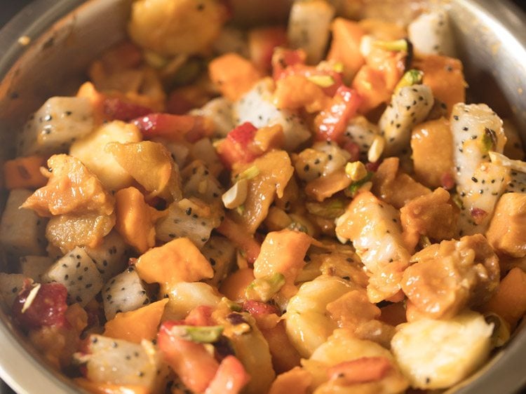 mixing the chopped nuts with the mixed fruits. 