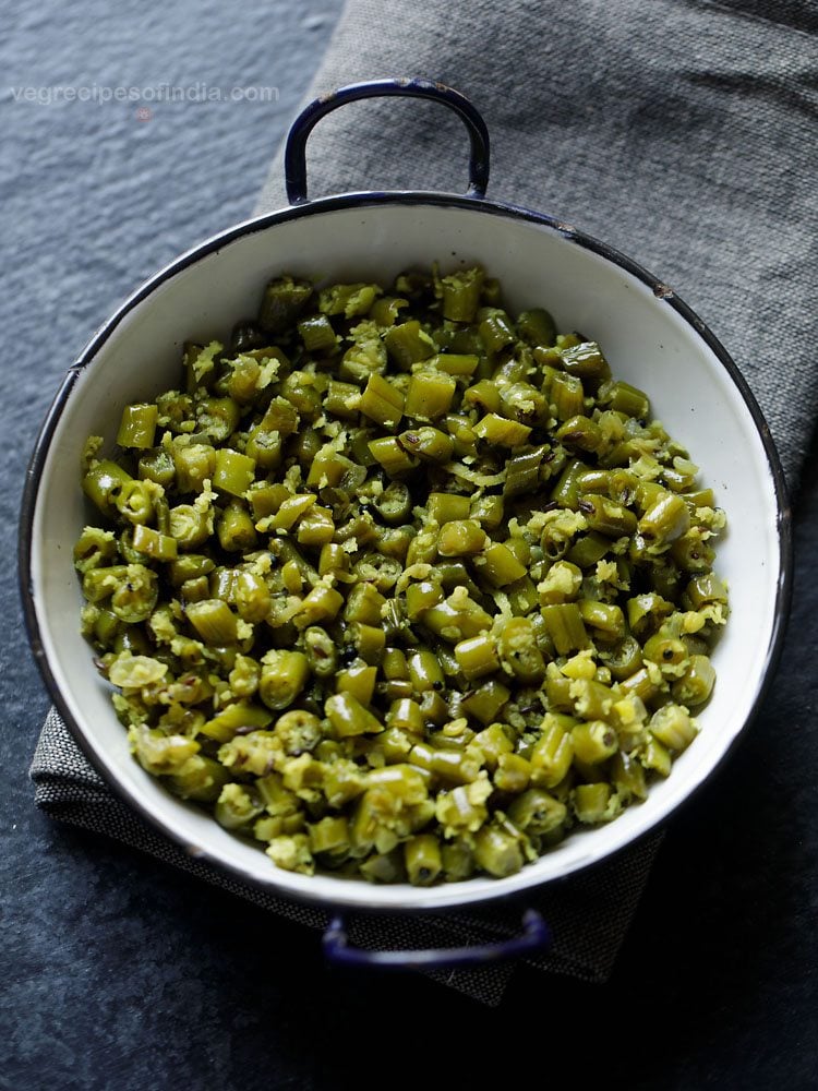 beans thoran served in a black rimmed pot. 