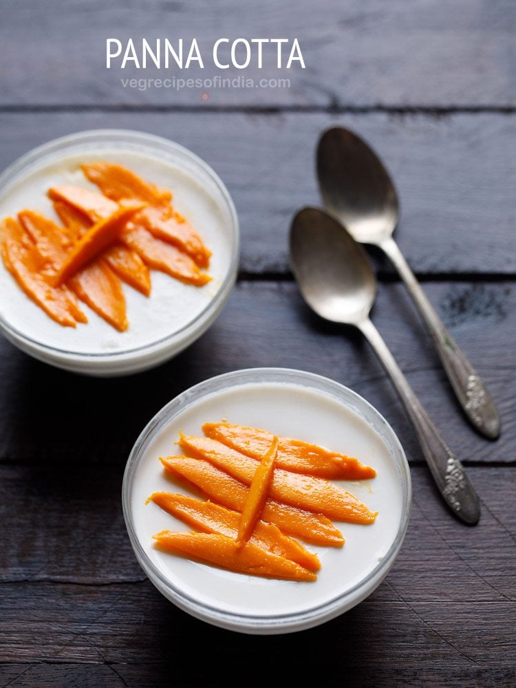 two bowls of panna topped with mango slices with a side of dessert spoons.