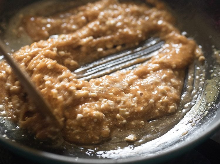 mixing the crushed cashewnuts with the molten liquid in the pan 