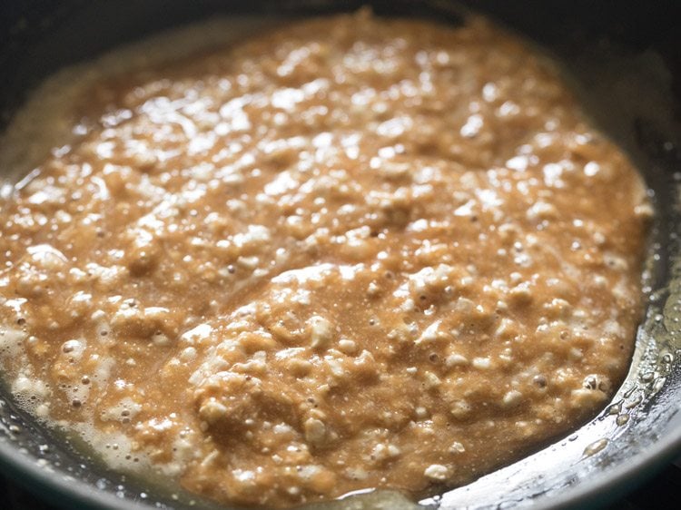 mixing the crushed cashewnuts with the molten liquid in the pan 