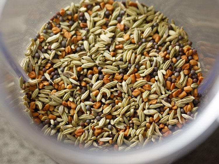 mustard seeds, fennel seeds and fenugreek seeds in a a small grinder jar 