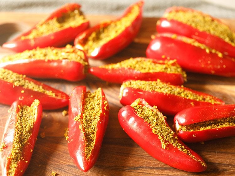 stuffing the prepared pickle masala in the prepared red chilies 