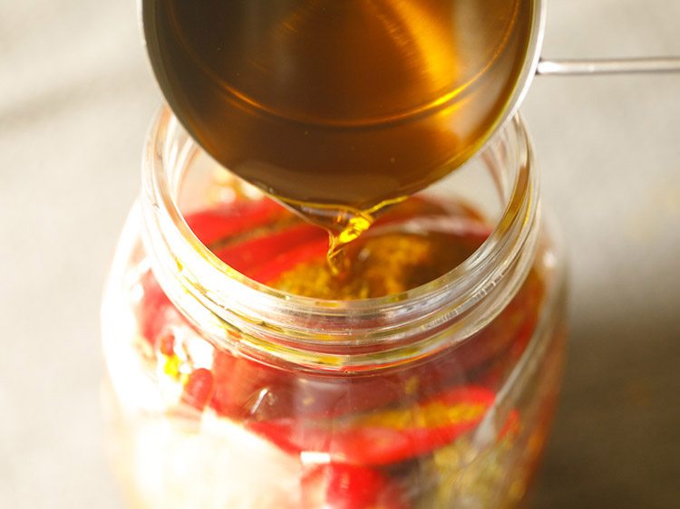 pouring mustard oil in the jar 