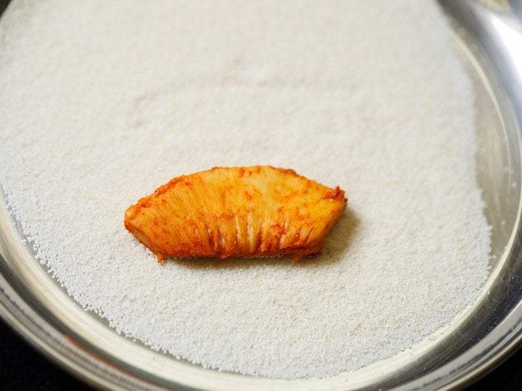 marinated breadfruit slice placed on rava. 