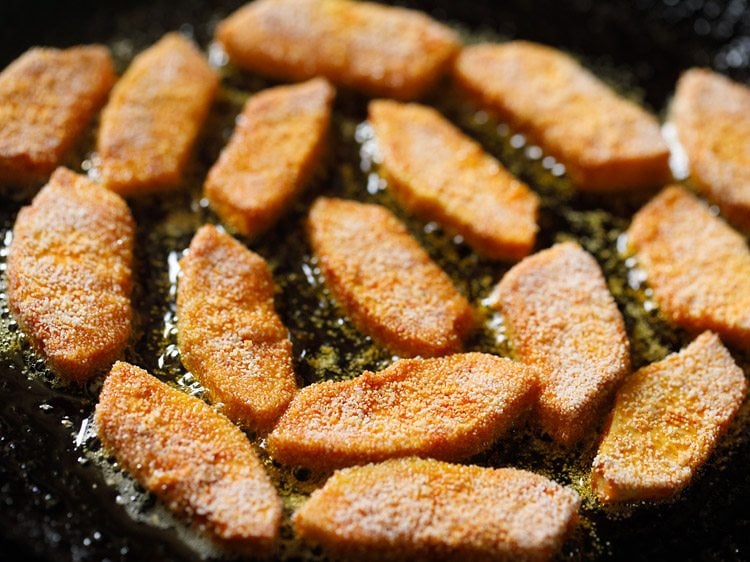 frying breadfruit slices in hot oil. 