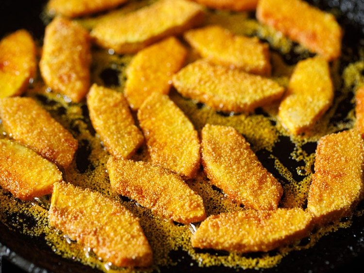 frying breadfruit slices in hot oil. 