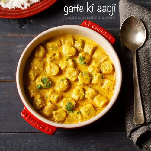 gatte ki sabji garnished with coriander leaves and served in a red color ceramic casserole.