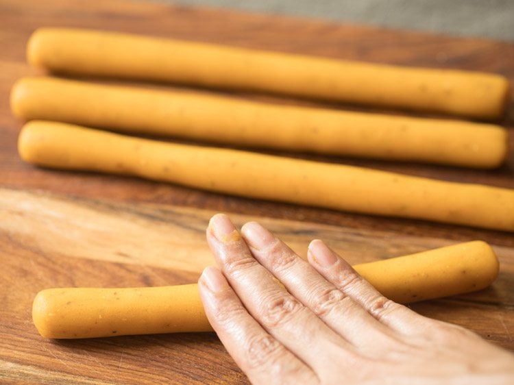 rolling dough balls into a soup stick like cylindrical shape. 