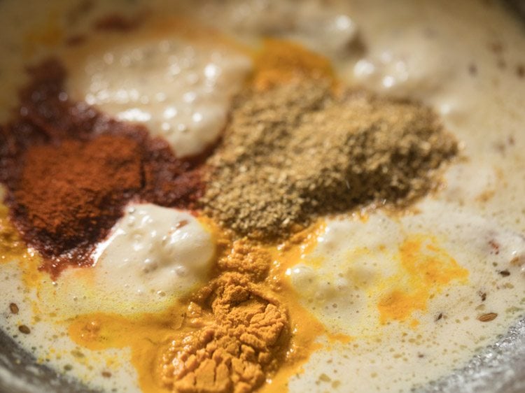 spice powders added to curd getting cooked. 