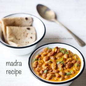 madra recipe garnished with coriander leaves and served in a black rimmed bowl with a bowl of chapatis and a spoon kept in the background and text layover.