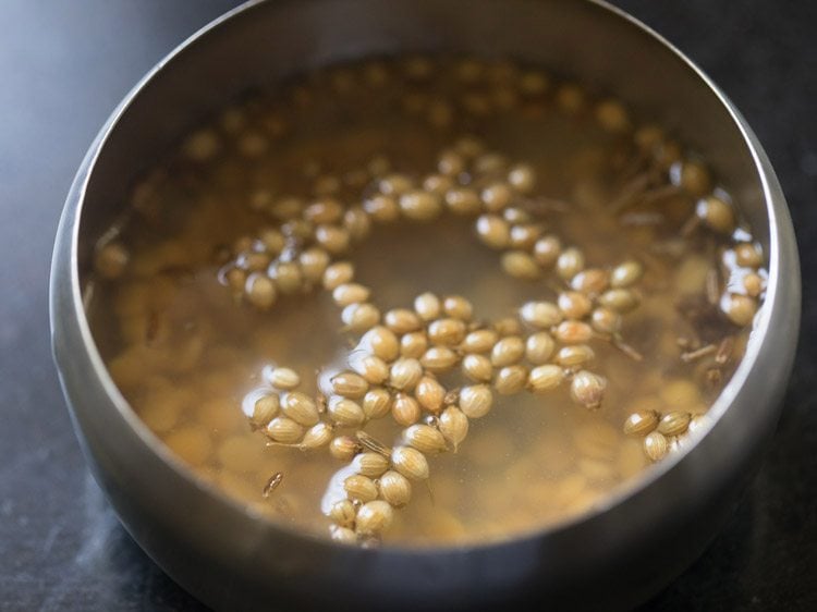 ingredients soaking in hot water for making paste for mor kuzhambu. 