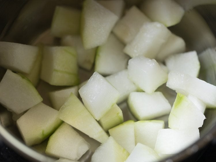 chopped ash gourd added in a pan for mor kuzhambu. 