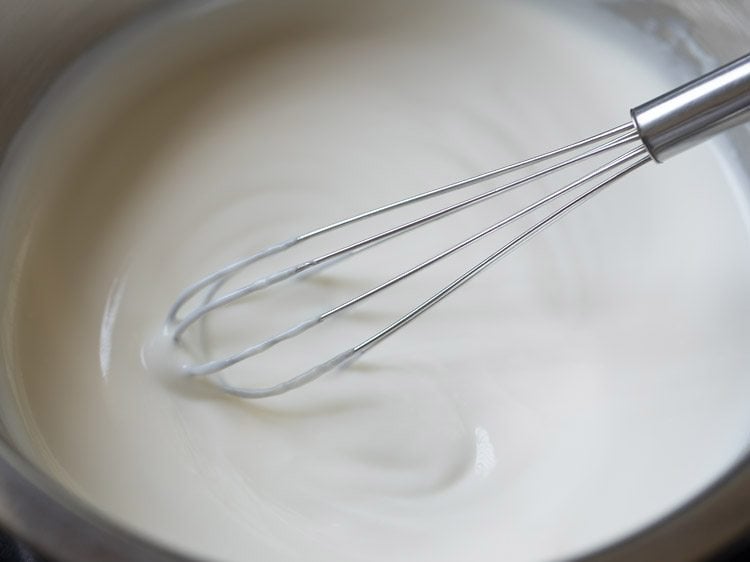 beating sour curd in a bowl for mor kuzhambu. 