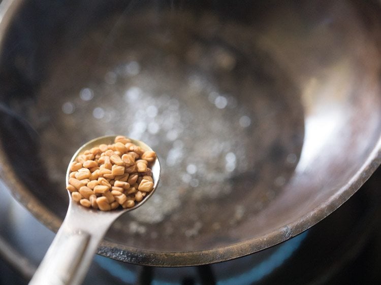 adding fenugreek seeds in hot oil. 