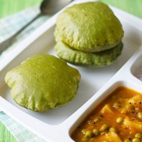 palak puri served in a sectioned platter with aloo matar, onions on the side and a spoon kept on the top in the background and text layover.