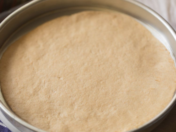 rolled pizza base placed in the prepared baking tray. 