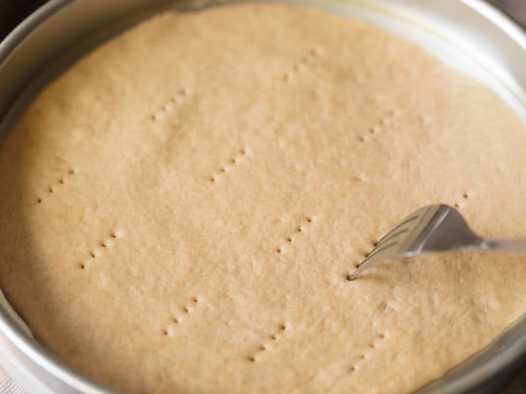 poking the rolled pizza base with a fork. 