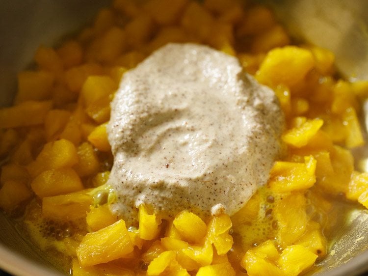 coconut spice paste added to the pan for making pineapple pachadi recipe.