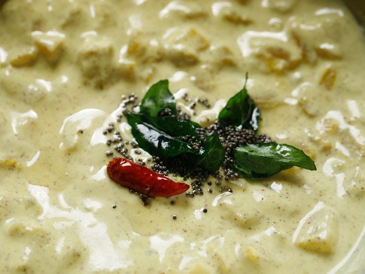 tadka poured over pineapple pachadi in a mixing bowl.