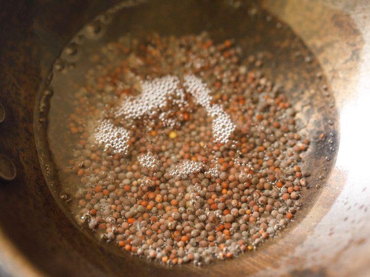 mustard seeds added to hot coconut oil for making. 