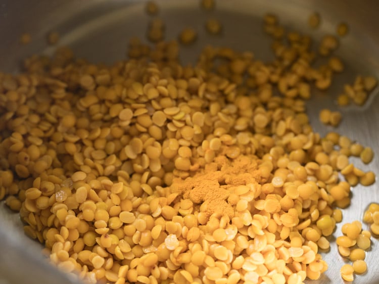 tuvar dal and turmeric powder added in a pressure cooker. 