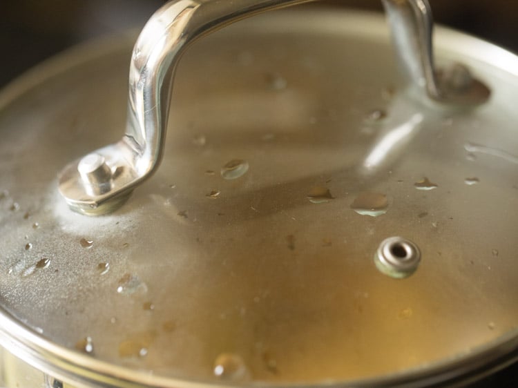 coking the raw mango cubes in the covered pan. 