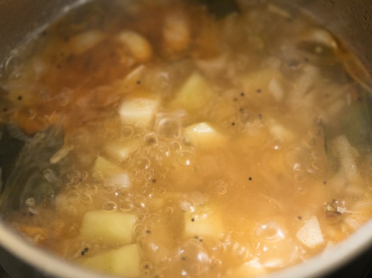 cooking raw mango cubes in the pan. 