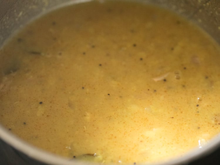 mixing the lentils with the raw mango cubes mixture. 