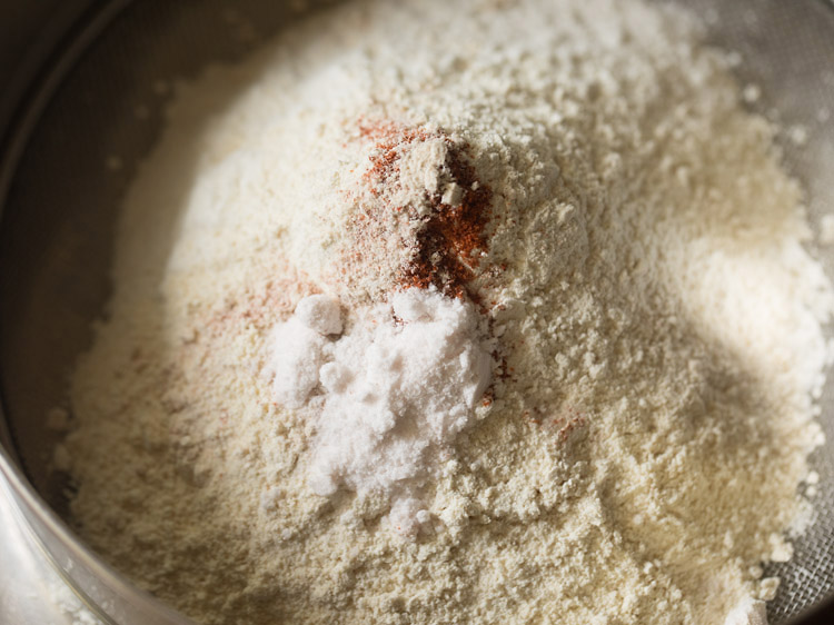 red chili powder, asafoetida and salt added to the flours in the sieve. 