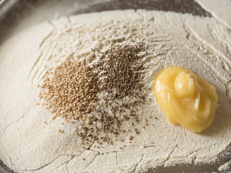 white sesame seeds, carom seeds and ghee added to sifted dry ingredients. 