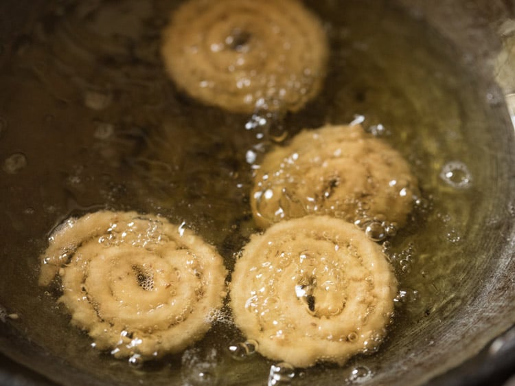 turning murukkus in oil.