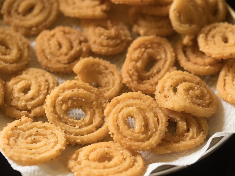 fried murukku placed on kitchen paper towels.