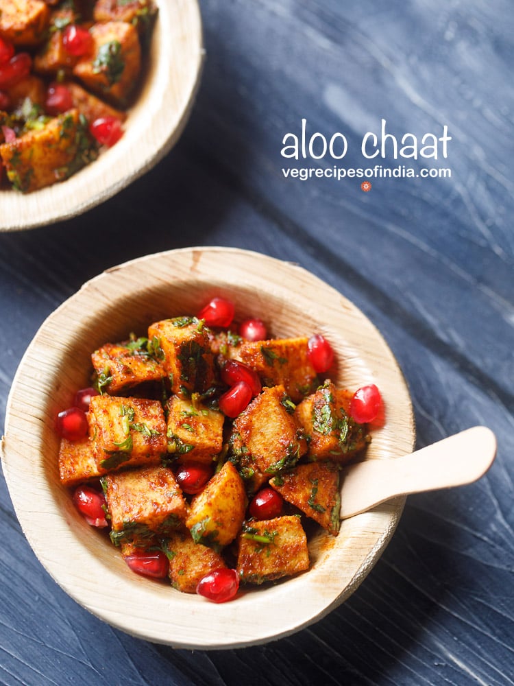 aloo chaat served with pomegranates in a wooden bowl with a fork