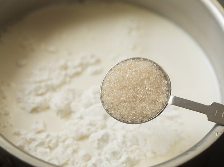 sugar being added to milk and cornstarch mix.