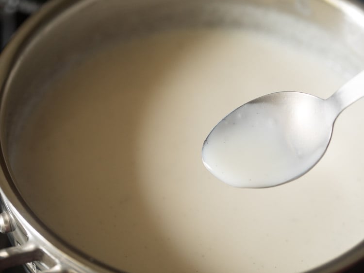 spoonful of egg free crème anglaise showing slightly thin consistency.