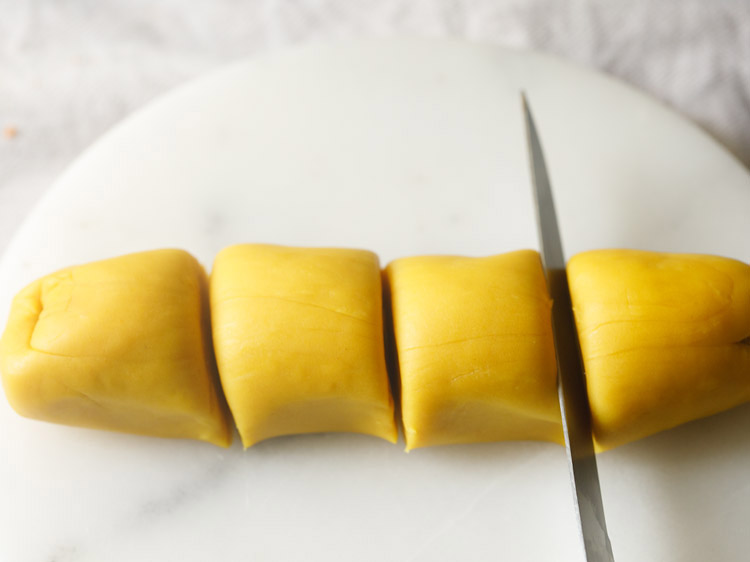 prepared dough shaped into a log and cut into equal parts for making bakarwadi. 