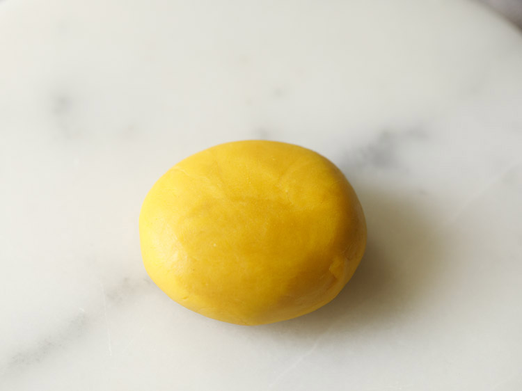 dough portion flattened and placed on rolling board.  