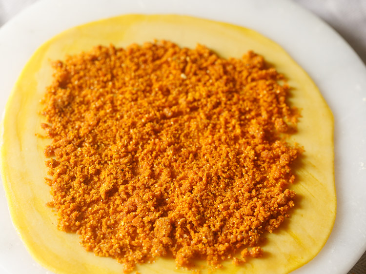 prepared stuffing mixture spread in the center of the rolled dough disc, leaving some space at the edges. 