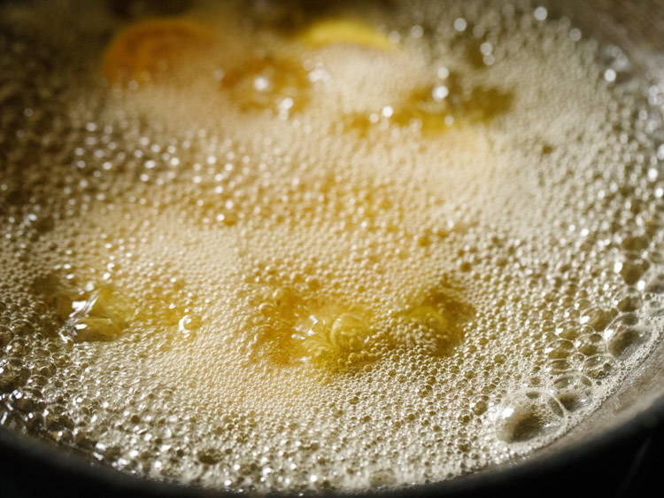 frying bakarwadi pinwheels in hot oil. 