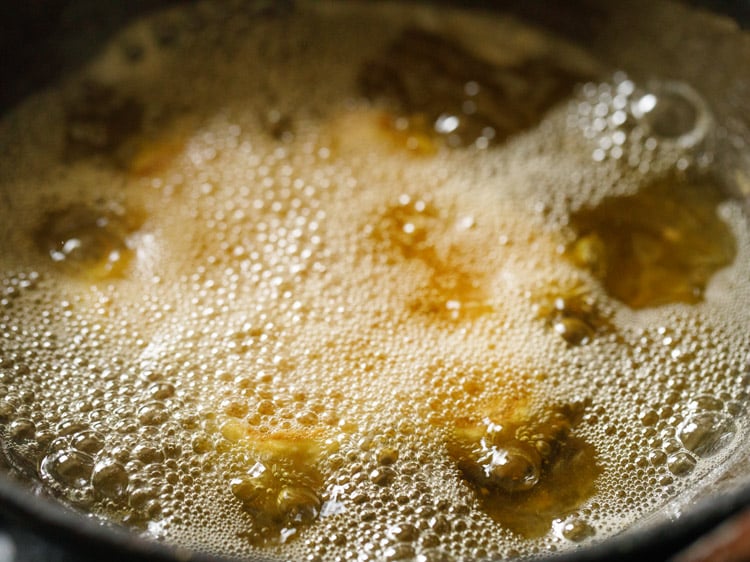 frying bakarwadi pinwheels in hot oil. 