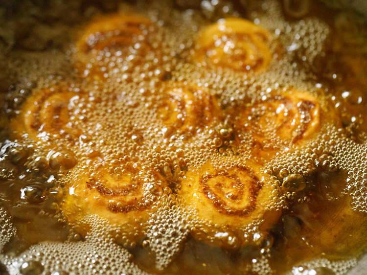 frying bakarwadi pinwheels in hot oil till evenly golden from both sides. 