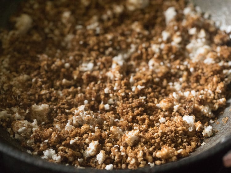 coconut mixed with the jaggery in the pan for making kolukattai recipe. 