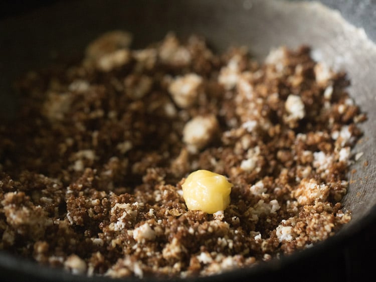 ghee added to the coconut-jaggery mixture in the pan.