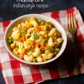 macaroni in a bowl on a red checkered napkin with fork at right side.