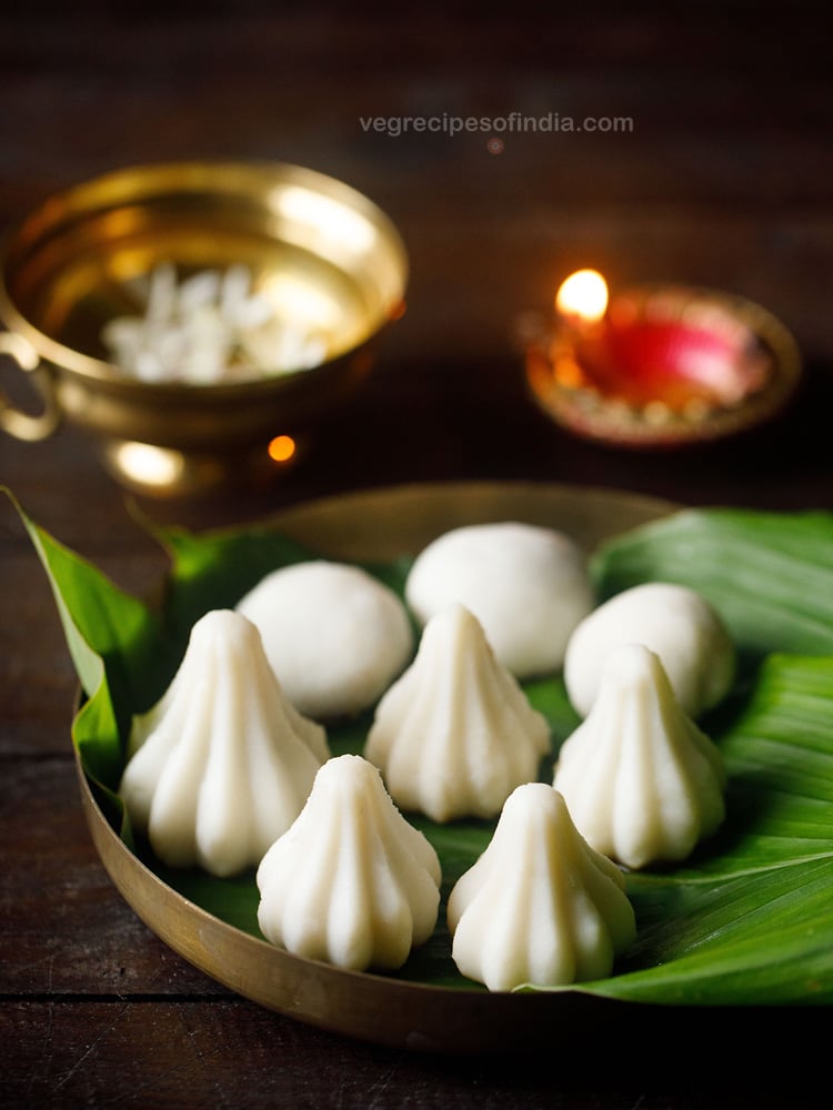 kozhukattai placed on turmeric leaves and served on a plate with text layovers. 