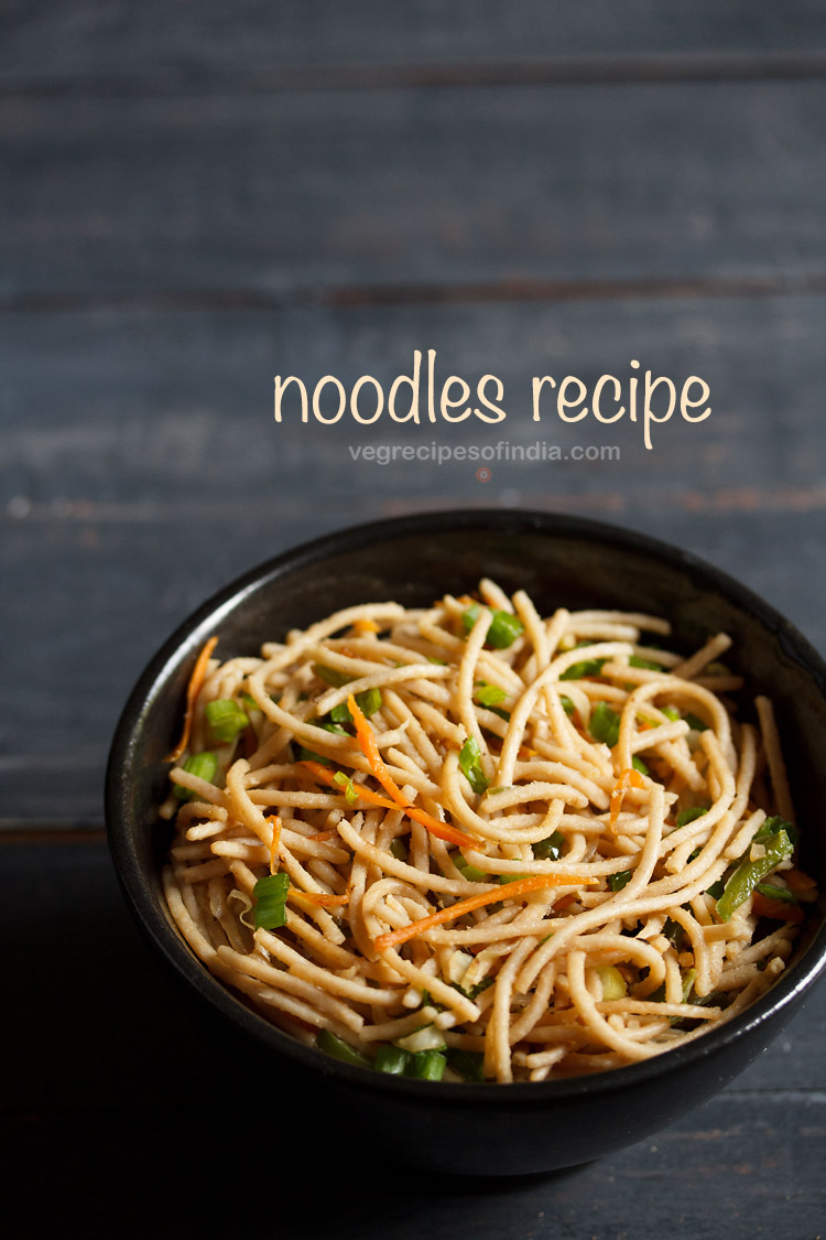 veg noodles served in a black bowl on a dark blue-gray wooden board