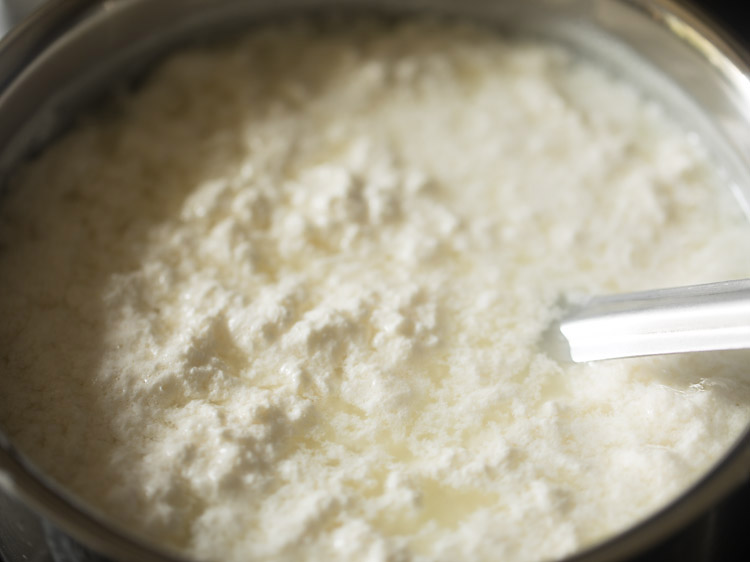 mixing vinegar in the boiled milk to curdle it for making chenna for chum chum. 