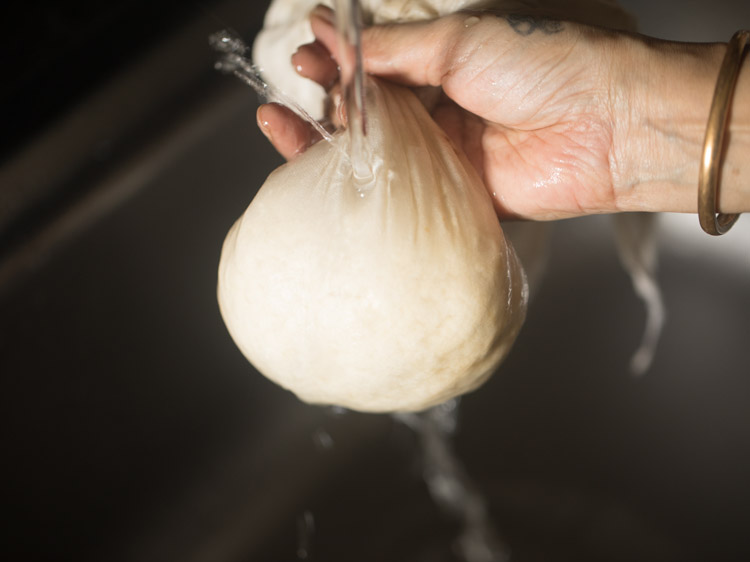 rinsing chenna in running water and squeezing put excess water from the chenna for chum chum. 